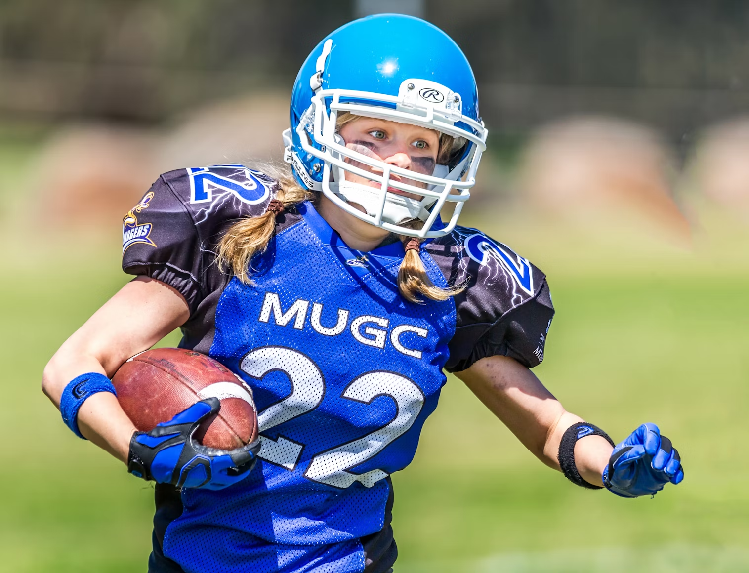 Young female football player running
