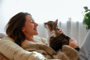 woman holding support cat on couch