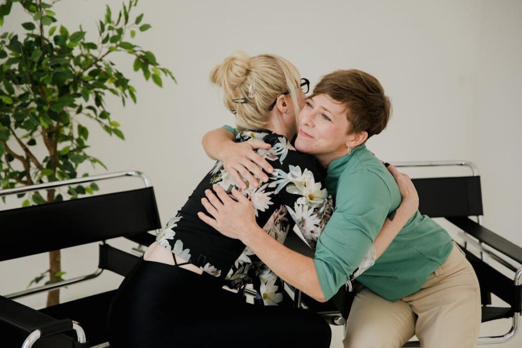 Free Two women sharing a comforting hug in a therapy session, symbolizing trust and support. Stock Photo