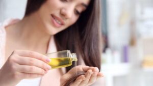 A young woman applying abyssinian seed oil at home.